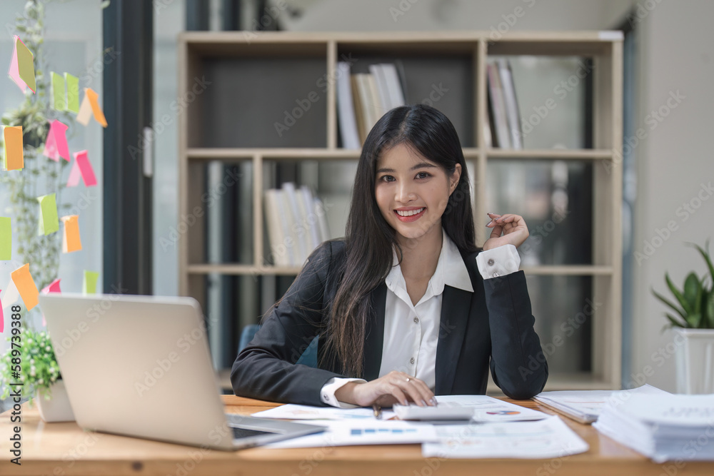 Woman accountant using calculator and computer in office finance and accounting concept Woman accountant using calculator and computer in office finance and accounting concept