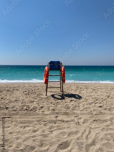 Fototapeta Naklejka Na Ścianę i Meble -  Lifeguard chair on a deserted beach on a sunny spring morning