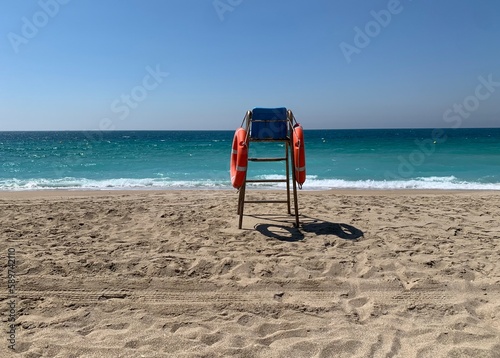 Fototapeta Naklejka Na Ścianę i Meble -  Lifeguard chair on a deserted beach on a sunny spring morning