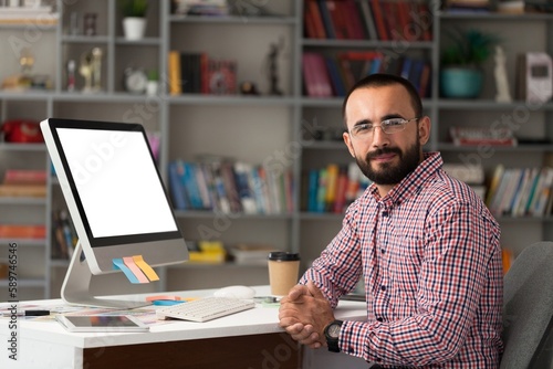 Bearded businessman working on laptop in office. Video online webinar.