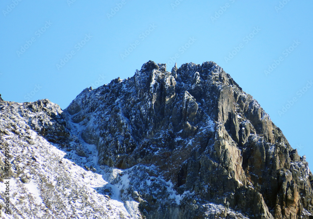 First snow on the rocky mountain peak Piz Sarsura (3175 m) in the Albula Alps and above the alpine valley Val Grialetsch, Zernez - Canton of Grisons, Switzerland (Kanton Graubünden, Schweiz)