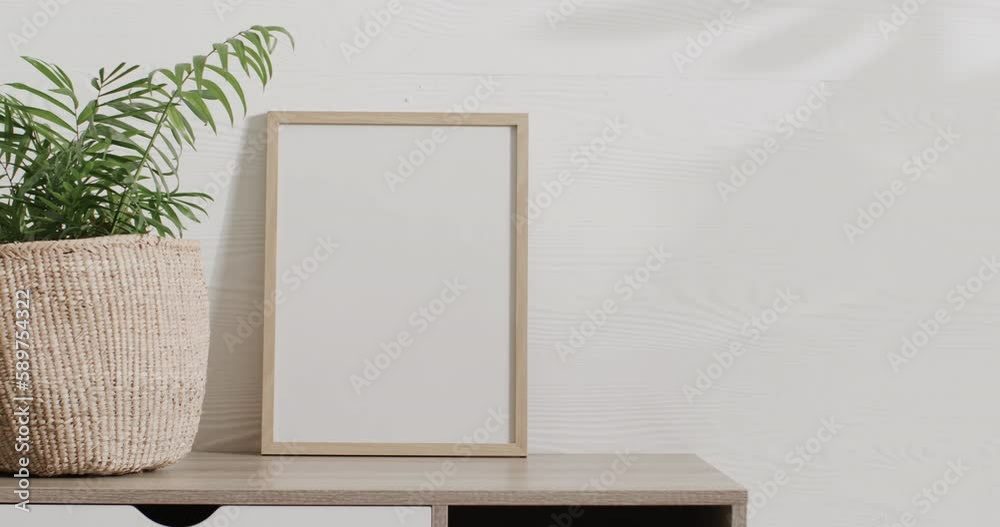 Wooden frame with copy space on white background with plant on desk against white wall