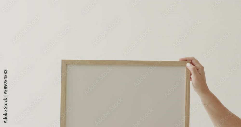 Hands of caucasian woman holding frame with copy space on white background against white wall