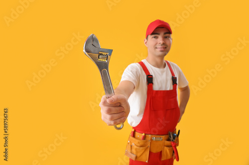 Young plumber with wrench o...