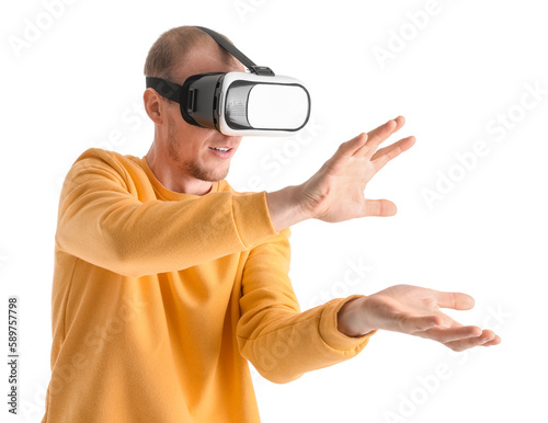 Young man using VR glasses on white background © Pixel-Shot