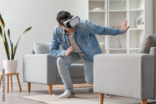 Young man using VR glasses ...