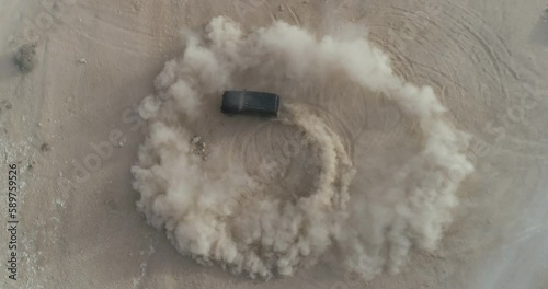 Eye bird Drone Shot for a an Off Road solo 4X4 car drifting in the middle of a desert valley in Wadi Degla Valley in Egypt photo