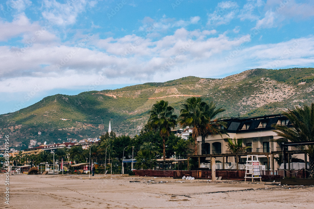 Hotels and cafes on the beach with mountains in the background