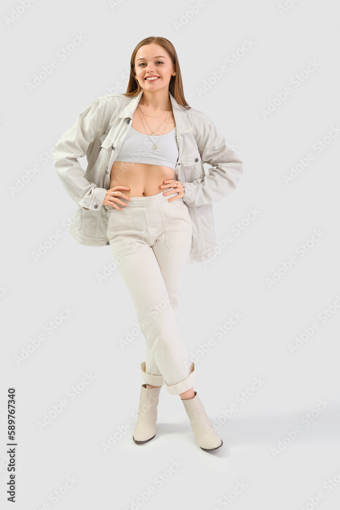 Pretty young woman in stylish clothes on light background Pretty young woman in stylish clothes on light background