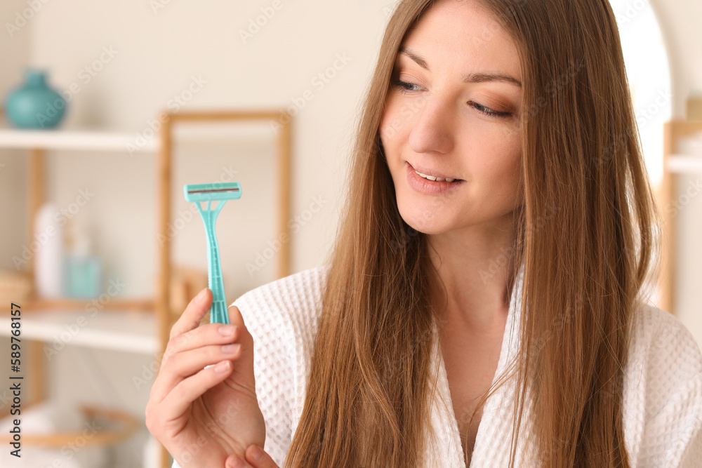 Pretty young woman with razor in bathroom Pretty young woman with razor in bathroom