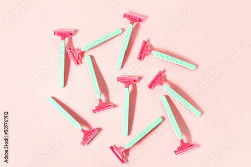 Composition with colorful safety razors on pink background