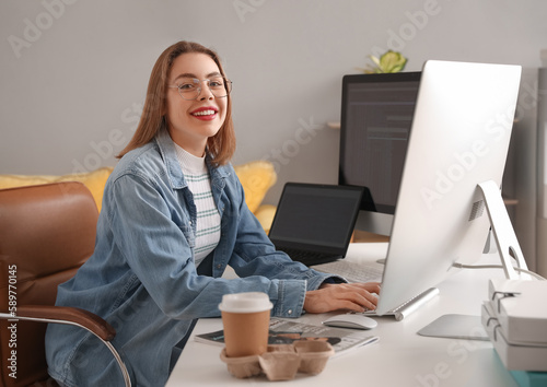 Smiling young woman working...