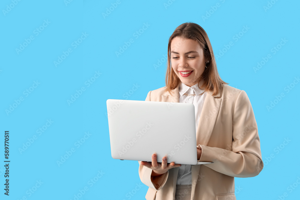 Female programmer working with laptop on blue background Female programmer working with laptop on blue background