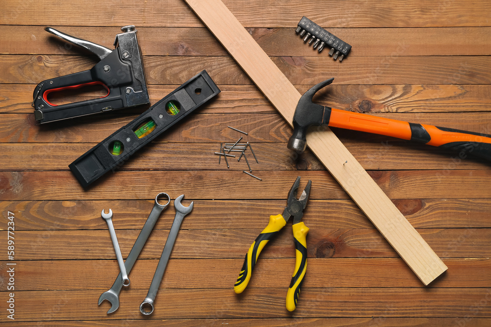 Composition with pliers, nails, plank and tools on wooden table Composition with pliers, nails, plank and tools on wooden table