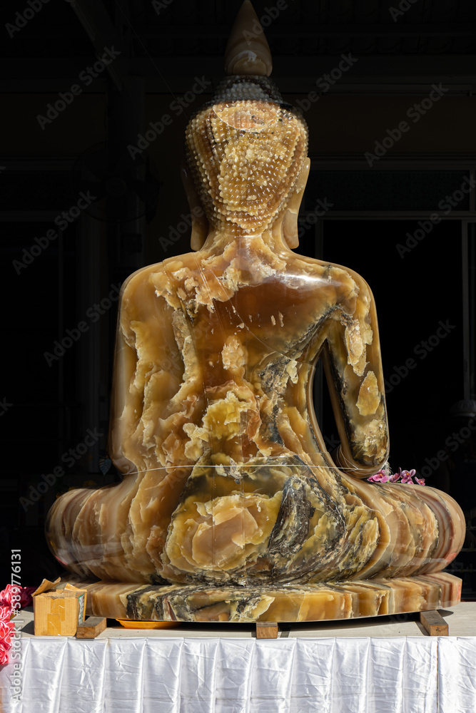 Carved statue of seated Buddha in Buddhist monastery, Thailand Carved statue of seated Buddha in Buddhist monastery, Thailand