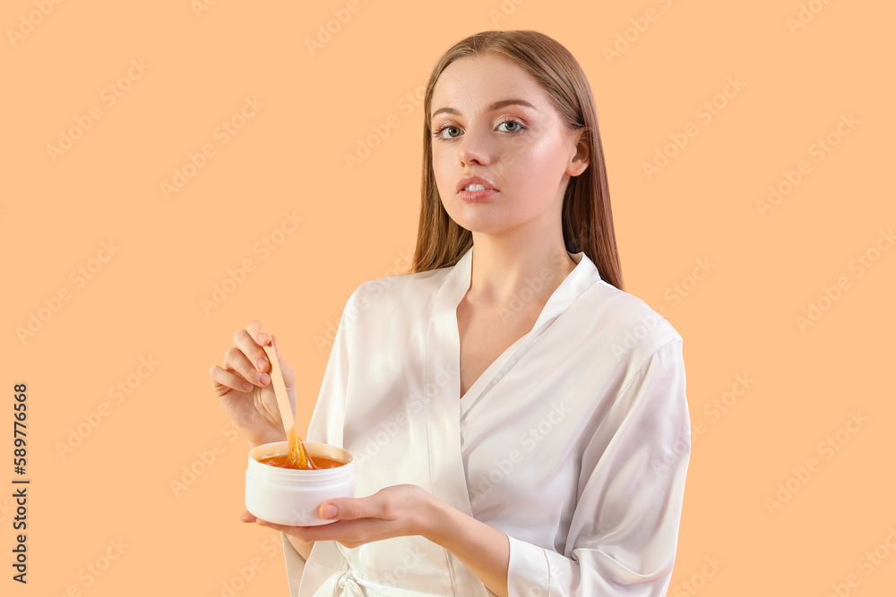 Pretty young woman with sugaring paste on beige background Pretty young woman with sugaring paste on beige background