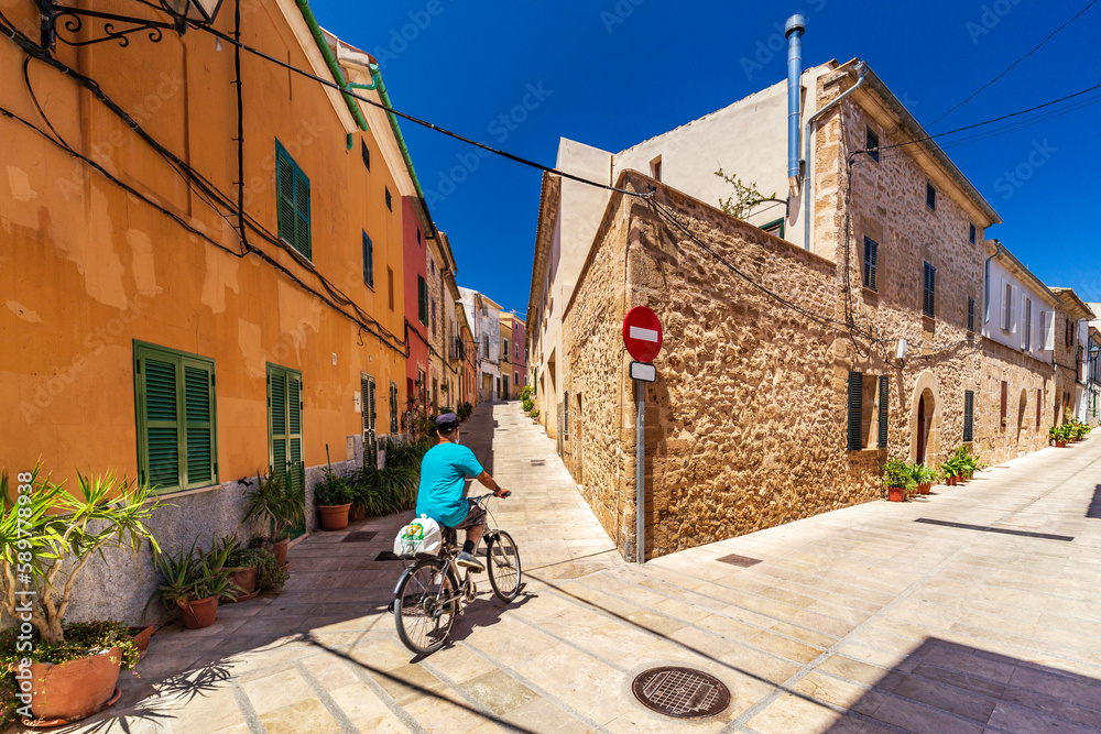 A man on a bike in the ancient town in Mallorca. 