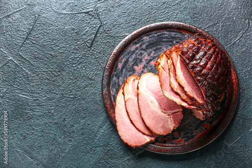 Plate with tasty smoked ham on dark background