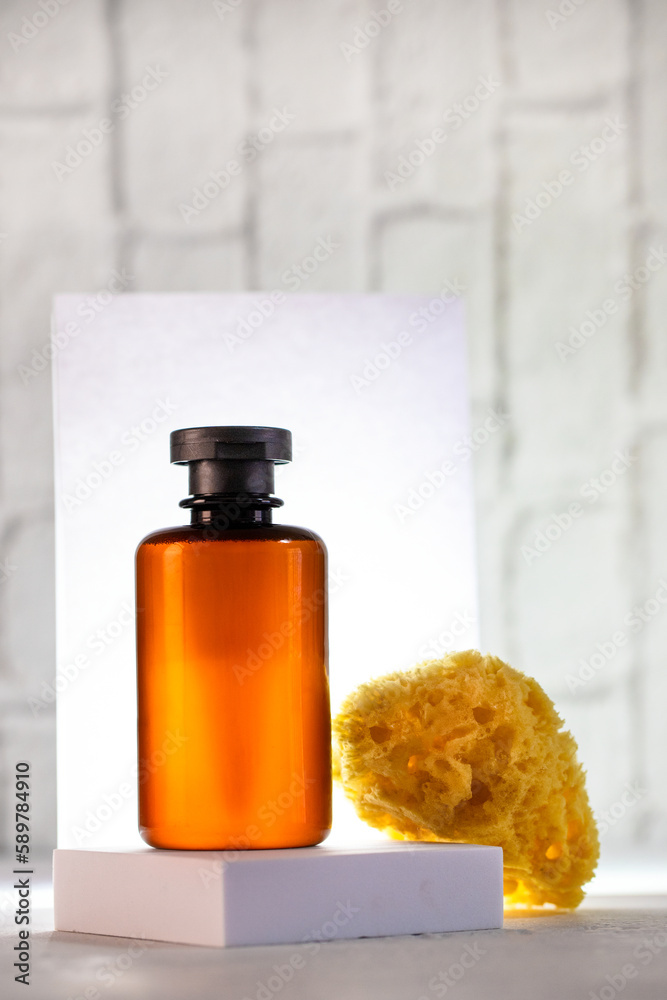 Cosmetic bottle on the podium and sea sponge at white background with back light. Cosmetic bottle on the podium and sea sponge at white background with back light.
