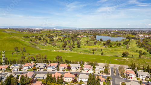 Drone photos over the city of Antioch, California on a beautiful sunny day with green hills, streets, houses, cars and solar.