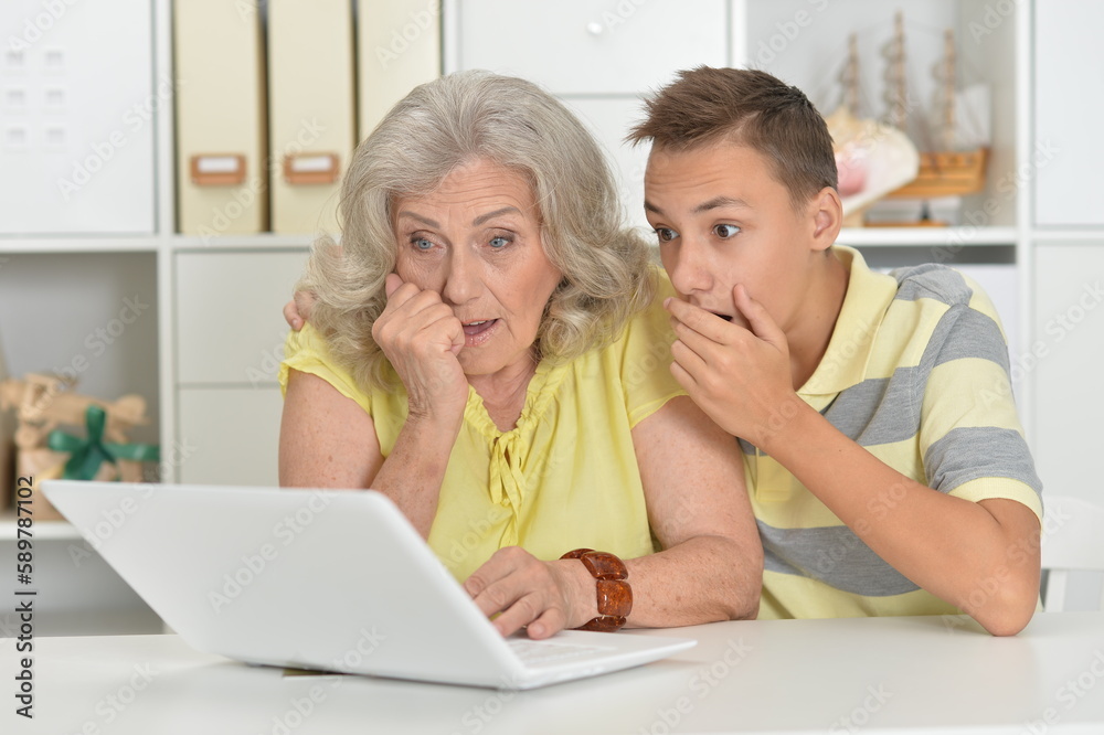 Grandmother with grandson using laptop at home Grandmother with grandson using laptop at home