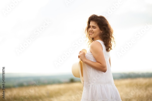 Woman in a hat on field wheat background