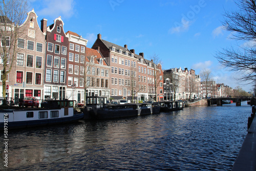 canal, river and old brick houses or flat buildings in amsterdam (the netherlands) © frdric