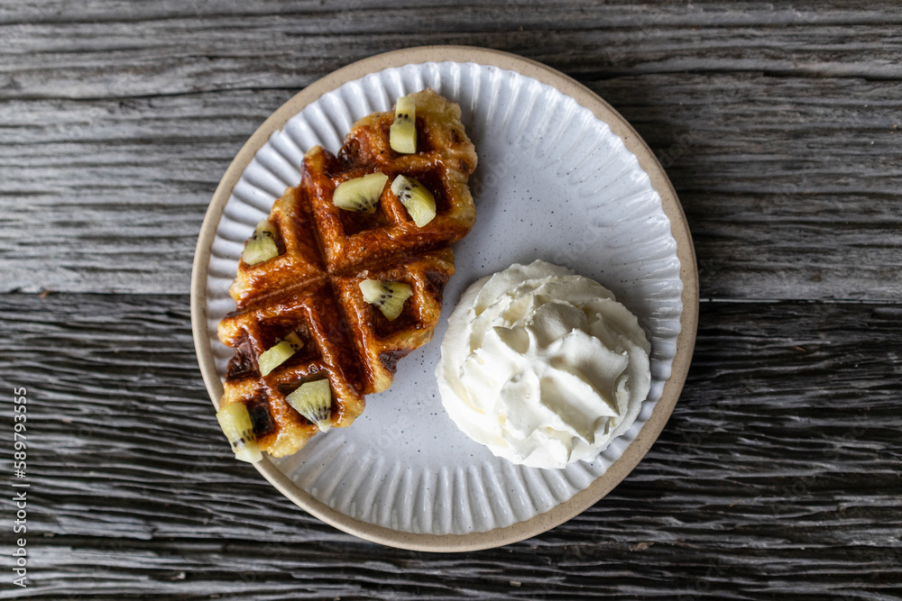 Waffle and cream on a white plate Waffle and cream on a white plate