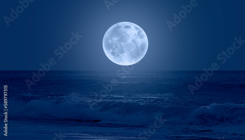Super Full Moon. Colorful sky with cloud and bright full moon over seascape "Elements of this image furnished by NASA"