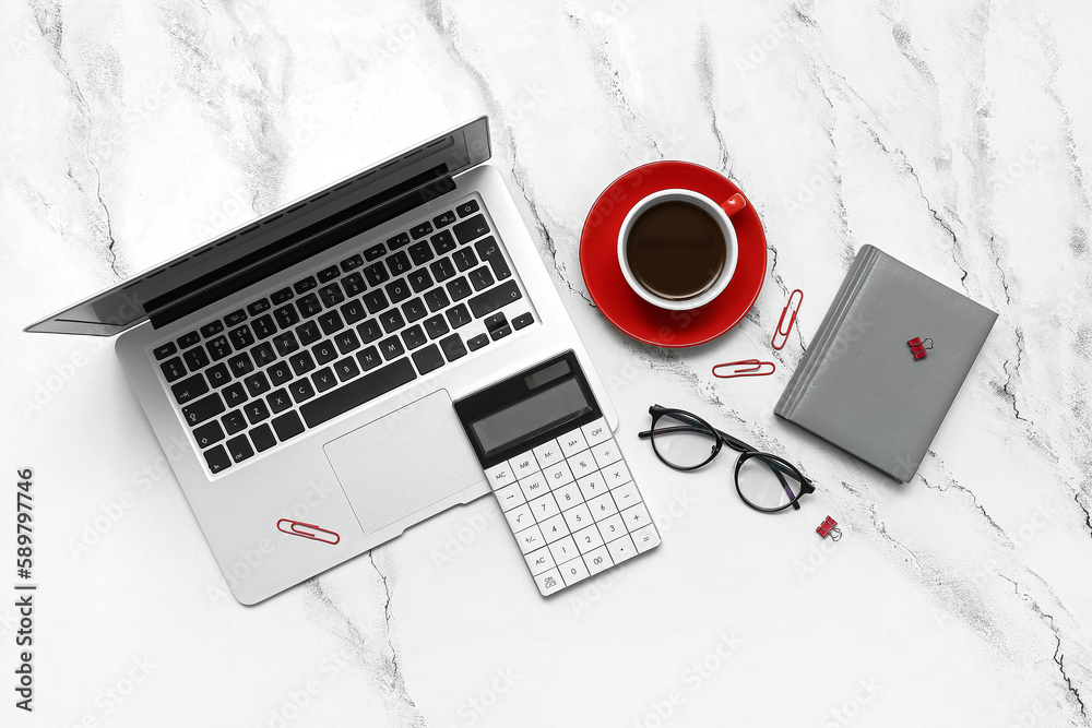 Composition with laptop, coffee, eyeglasses and notepad on light background Composition with laptop, coffee, eyeglasses and notepad on light background