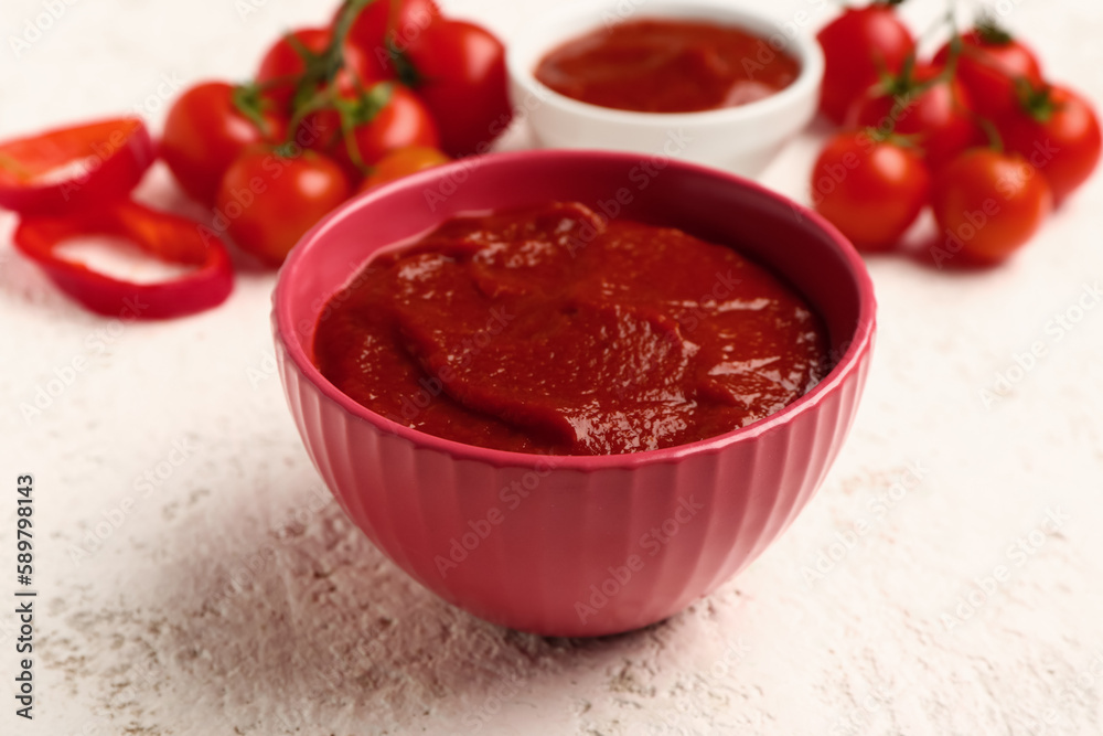 Bowl with tasty tomato paste on light background, closeup