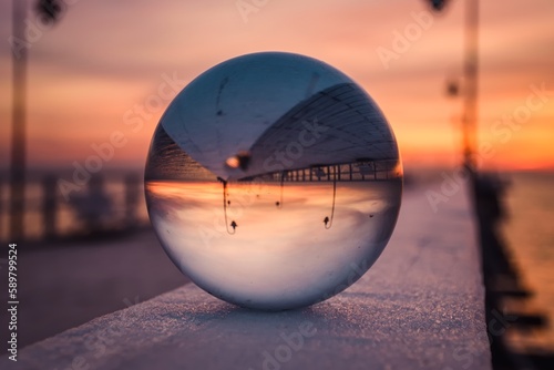 Abstract idea with water with an interesting effect. Glass ball on a blurred background on a seaside beach in Gdynia  Poland. Photo with a shallow depth of field.