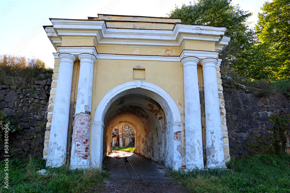 Fototapeta premium Stone roadway and old gate near the city of Vyborg, Russia. Bright autumn landscapes of popular tourist destination and landmark.