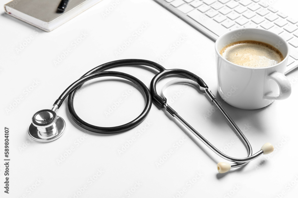 Stethoscope, cup of coffee and pc keyboard on doctor's table Stethoscope, cup of coffee and pc keyboard on doctor's table