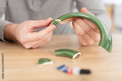 male hands repairing broken flower pot
