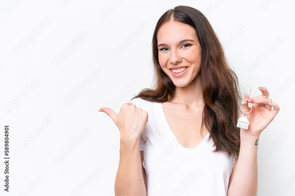 Young caucasian woman holding home keys isolated on white background pointing to the side to present a product Young caucasian woman holding home keys isolated on white background pointing to the side to present a product