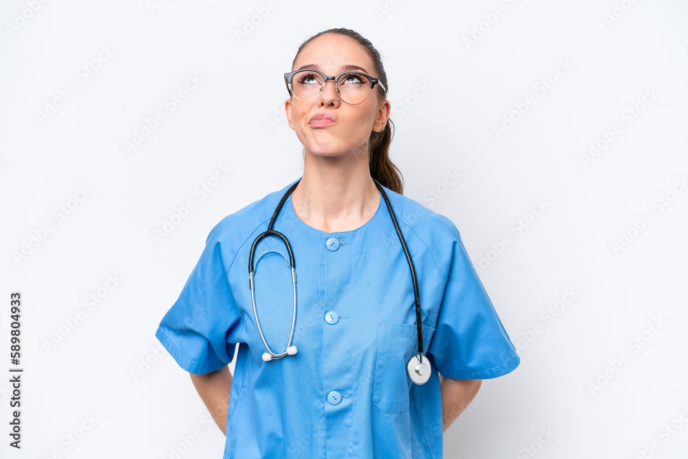 Young caucasian surgeon doctor woman isolated on white background and looking up Young caucasian surgeon doctor woman isolated on white background and looking up