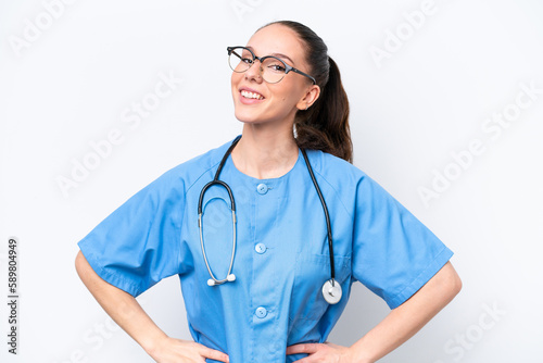 Young caucasian surgeon doctor woman isolated on white background posing with arms at hip and smiling © luismolinero