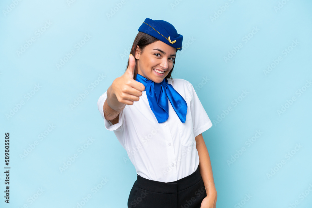 Airplane stewardess caucasian woman isolated on blue background with thumbs up because something good has happened Airplane stewardess caucasian woman isolated on blue background with thumbs up because something good has happened