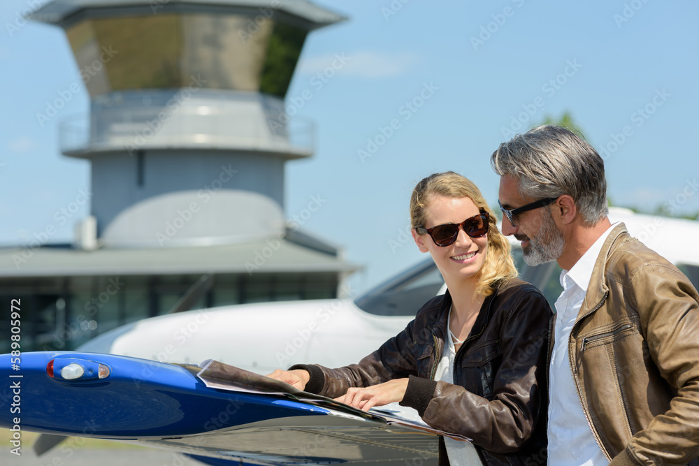 happy couple talking and flirting near private airplane