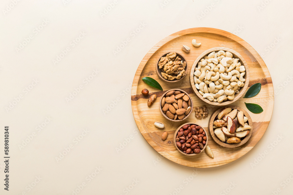 mixed nuts in wooden bowl. Mix of various nuts on colored background. pistachios, cashews, walnuts, hazelnuts, peanuts and brazil nuts mixed nuts in wooden bowl. Mix of various nuts on colored background. pistachios, cashews, walnuts, hazelnuts, peanuts and brazil nuts