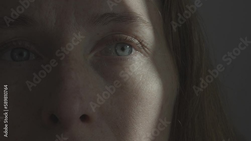 Portrait of a woman with a streak of sunlight across her eye and cheek. Psychology and psychiatry. Fear of the environment