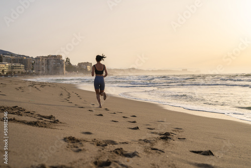 beautiful young girl running in the morning on the beach