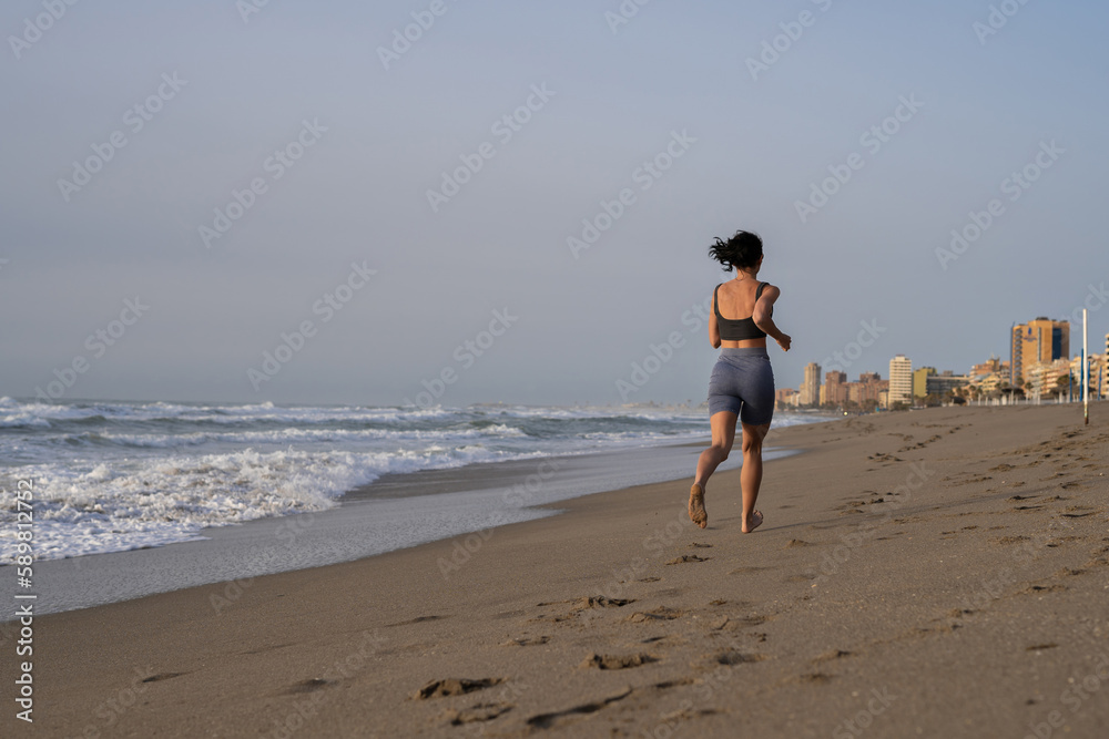 beautiful young girl running in the morning on the beach