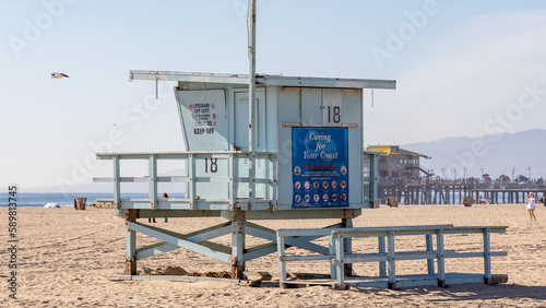 A lifeguard tower on Santa Monica beach with pier in the background located in California USA taken on February 5th 2023