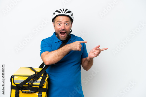 Middle age caucasian man with thermal backpack isolated on white background surprised and pointing side