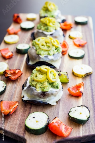 Vertical shot of burger sliders with pickled jalapenos and grilled veggies on a wooden table
