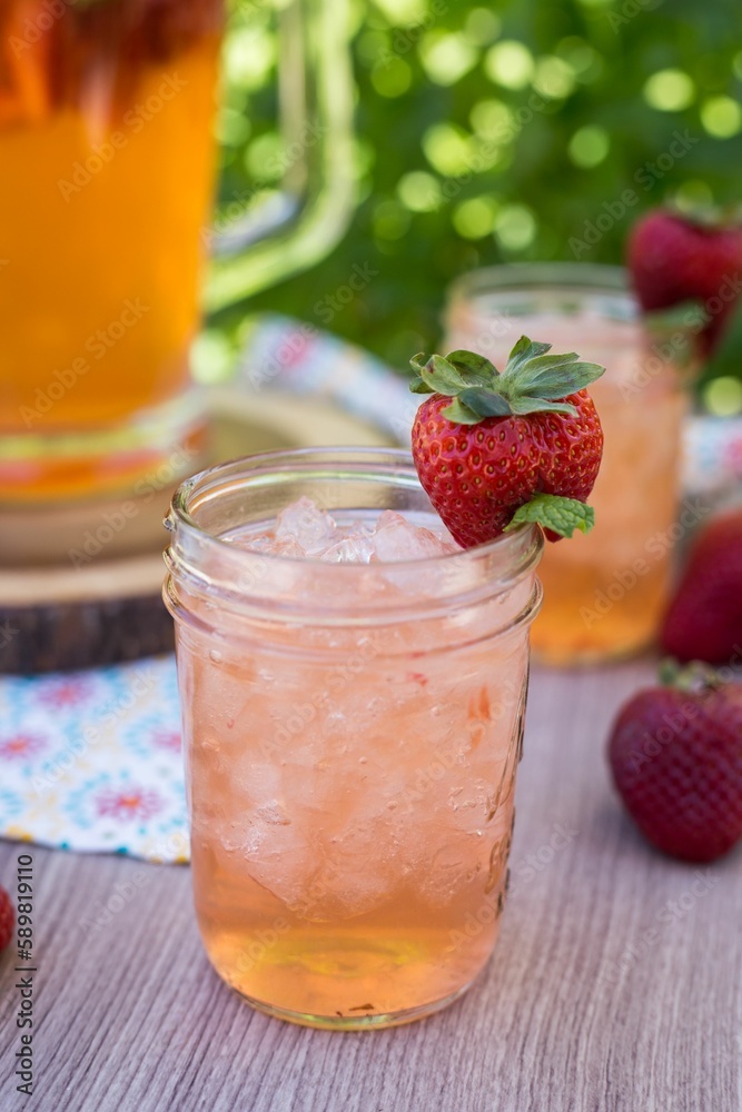 Vertical closeup shot of the glass of strawberry lemonade with ice, decorated by strawberry Vertical closeup shot of the glass of strawberry lemonade with ice, decorated by strawberry