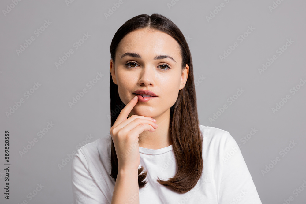 Portrait of beautiful thoughtful woman girl in doubt who stands on grey background wall with copy space shows different emotions isolated. Portrait of beautiful thoughtful woman girl in doubt who stands on grey background wall with copy space shows different emotions isolated.