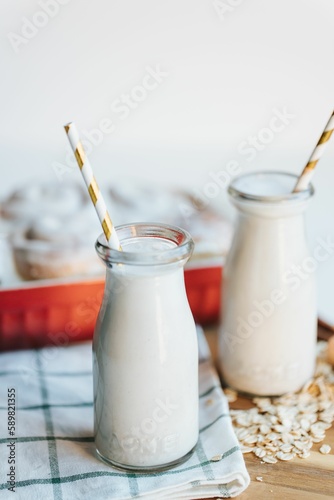 Vertical of the fresh milkshake and cinnamon rolls on the put on the wooden table